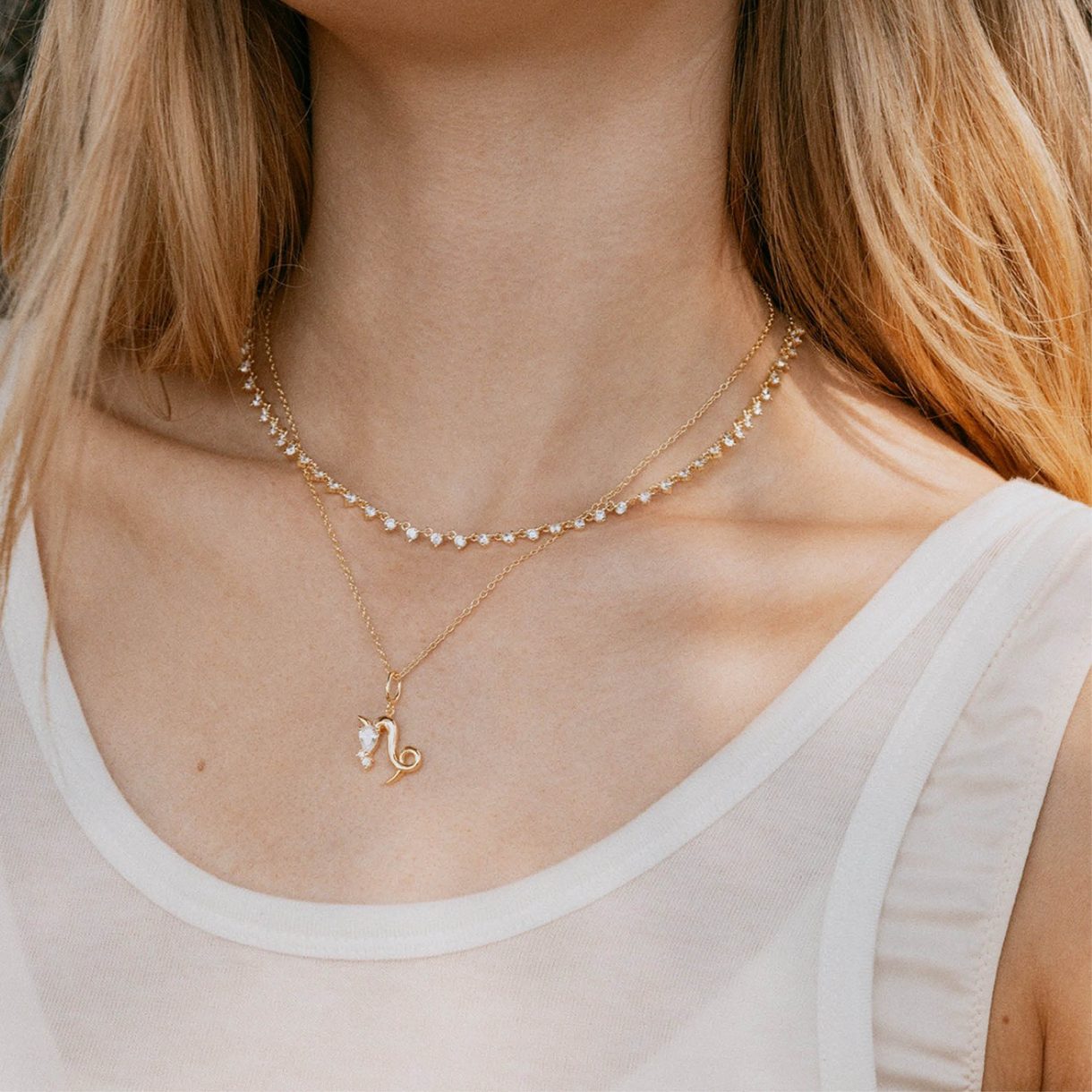 Zodiac sign necklace layered with a beaded chain