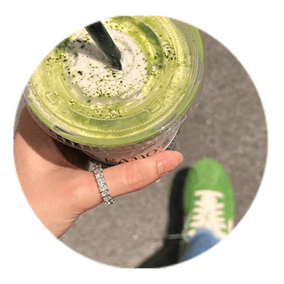 Hand holding an iced matcha while wearing a travel ring
