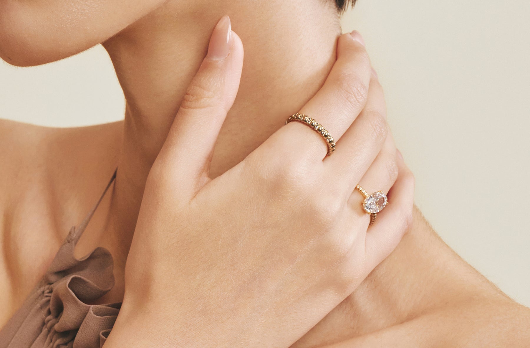 Gold eternity band and oval engagement ring worn together