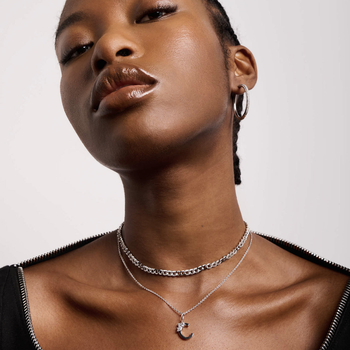 Model wearing layered initial necklaces
